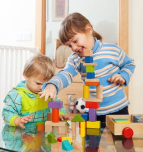 siblings together playing with toys