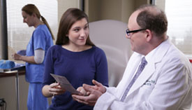 Doctor talking to patient holding brochure.